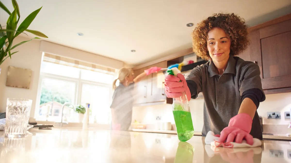 Professional residential cleaner working in a customer's kitchen
