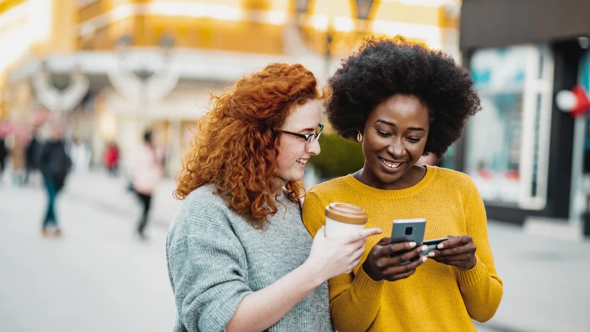 Two customers looking at a smartphone together